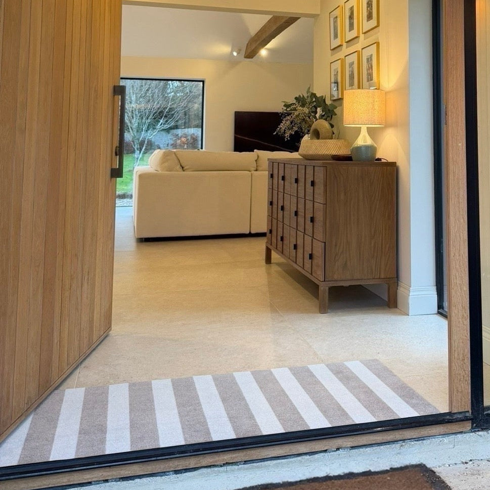 Modern interior with wooden walls, a glass door, and a living room.